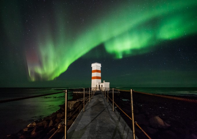 Aurora Borealis dancing over a lighthouse in Iceland