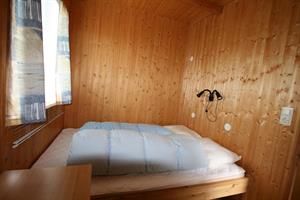 The bedroom of the three person cottage has a bunk bed and a double bed